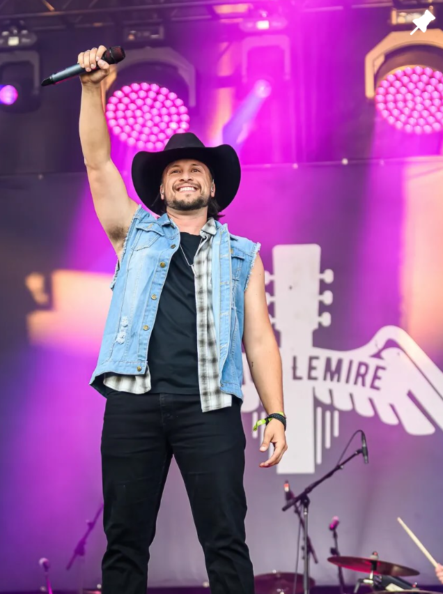 Vince Lemire qui lève le bras pour saluer la foule sur une scène au Québec